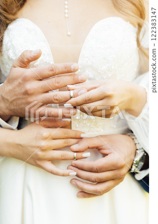 two gold wedding rings. the bride wears the groom wedding ring. newlyweds with rings on fingers. 122383147