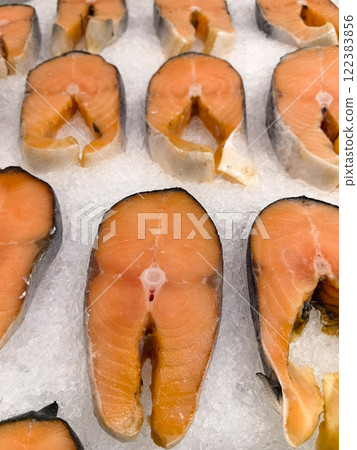 Fresh salmon fillets arranged neatly on crushed ice at a market 122383856
