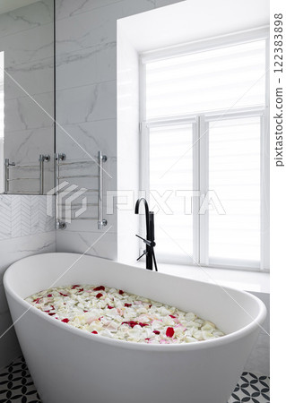 Indulge in a Luxurious Bathtub Adorned with Fresh Rose Petals in a Modern Bathroom Space Indulge in a Luxurious Bathtub Adorned with Fresh Rose Petals in a Modern Bathroom Space 122383898
