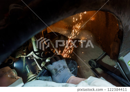 Automotive Technician Performing Welding Repairs Beneath a Vehicle Automotive Technician Performing Welding Repairs Beneath a Vehicle 122384411
