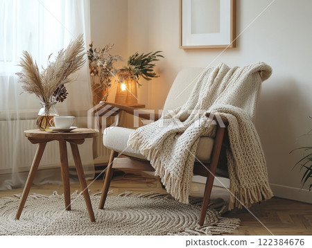 Cozy reading nook with comfortable chair, warm blanket, and tea cups in a serene living room. Cozy reading nook with comfortable chair, warm blanket, and tea cups in a serene living room. 122384676