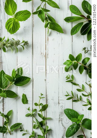 Flat lay arrangement of assorted green herbs on white wooden surface for culinary use 122385400
