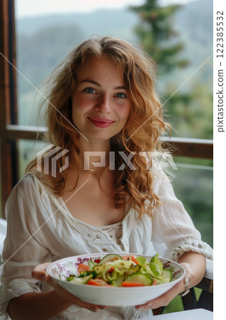 Stylish young woman enjoying a healthy salad on a restaurant terrace in summer 122385532