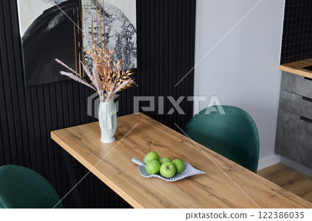 A contemporary modern dining room featuring chic minimalist decor and beautifully fresh apples 122386035