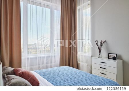A Cozy Modern Bedroom that features Natural Light and a Minimalist Design aesthetic A Cozy Modern Bedroom that features Natural Light and a Minimalist Design aesthetic 122386139