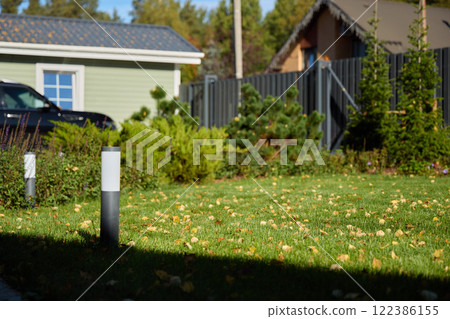 A Beautiful Sunny Autumn Garden, Enhanced with Decorative Lighting and Lush Greenery 122386155