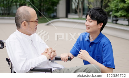 Caregiver talking to an elderly person in a wheelchair 122386722