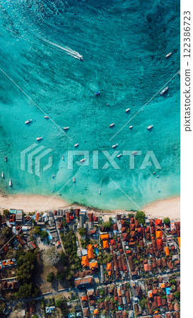 Nusa Lembongan island with coastline and turquoise sea with boats, above drone view, vertical screen 122386723