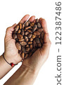 Isolated female hands holding a handful of cocoa beans. Table top view. 122387486