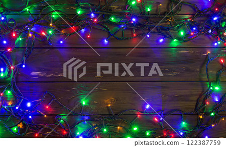 Christmas background with lights and free text space. Christmas lights. Glowing colorful Christmas lights . New Year. Garland. 122387759