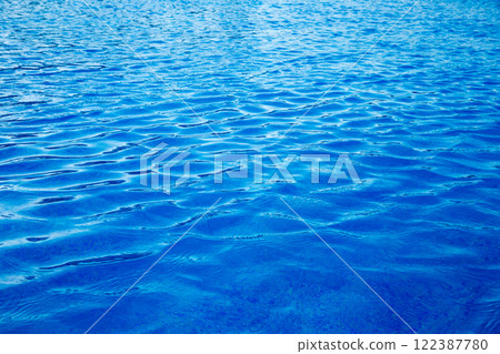 Water in swimming pool rippled water detail background. Blue in the water in the swimming pool. Water in swimming pool rippled water detail background. Blue in the water in the swimming pool. 122387780