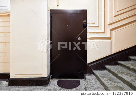 An Elegant Entrance Door accompanied by Stairs showcased within a Modern Interior design An Elegant Entrance Door accompanied by Stairs showcased within a Modern Interior design 122387910