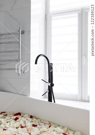 Contemporary Bathtub Featuring a Stylish Black Faucet Surrounded by Soft Rose Petals Contemporary Bathtub Featuring a Stylish Black Faucet Surrounded by Soft Rose Petals 122389123