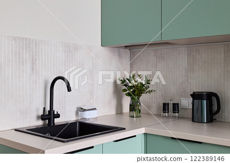 A modern kitchen with stylish fixtures, unique designs, and green cabinets for aesthetic appeal 122389146