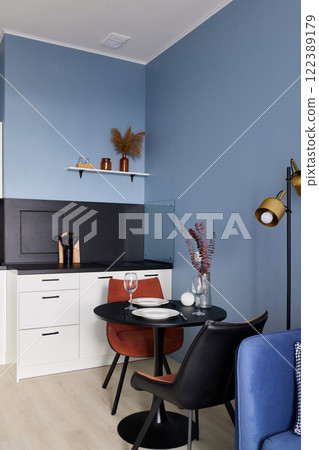 A modern and cozy kitchen dining area featuring stylish decor that creates a warm ambiance A modern and cozy kitchen dining area featuring stylish decor that creates a warm ambiance 122389179