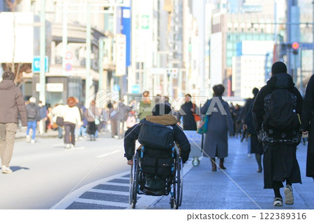 Wheelchair running through pedestrian precinct: A businessman in a wheelchair running through the pedestrian precinct in Ginza 122389316