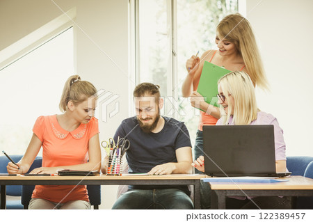 Students and teacher tutor in classroom Students and teacher tutor in classroom 122389457