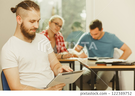 Student boy with tablet in front of her classmates Student boy with tablet in front of her classmates 122389752