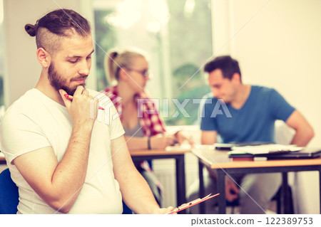 Student boy in front of her mates in classroom Student boy in front of her mates in classroom 122389753