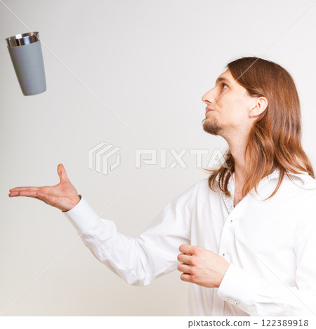 Skilled bartender juggling with glass. 122389918