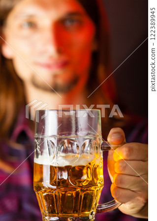 handsome young man holding a mug of beer handsome young man holding a mug of beer 122389945