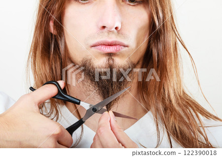 Man cutting his beard 122390018