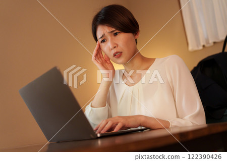 Tired woman working from home at night 122390426
