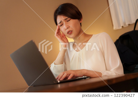 Tired woman working from home at night Tired woman working from home at night 122390427