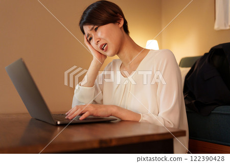 Tired woman working from home at night 122390428