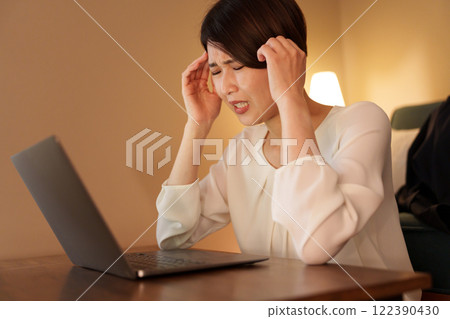Tired woman working from home at night 122390430