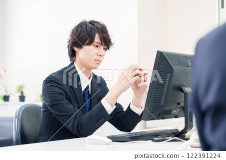 Businessman playing with Rubik's cube at work 122391224