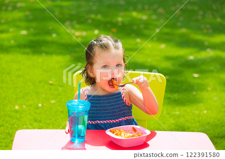 Toddler kid girl eating macaroni tomato pasta Toddler kid girl eating macaroni tomato pasta 122391580