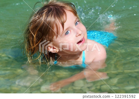 blond girl swimming in lake river 122391592