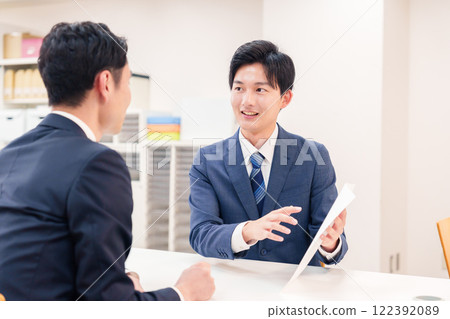 A businessman serving customers at the counter 122392089
