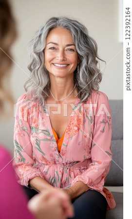 Older therapist smiles gently in a one on one session in warmly lit office 122392164