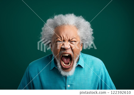 Elderly Black man with gray hair passionately expressing emotion against a solid background 122392610