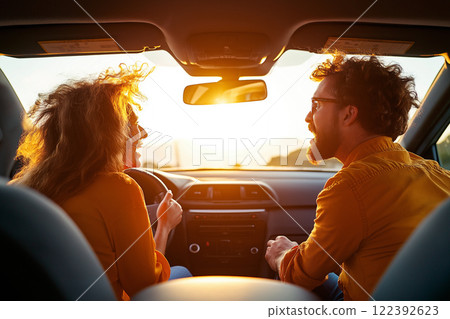 Arguments unfold between a couple in a car as the sun sets in the background 122392623