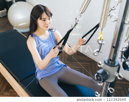 Woman doing machine pilates training 122392649
