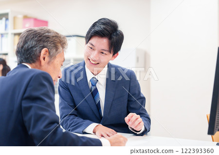 一名男子在櫃檯為老年顧客服務 122393360