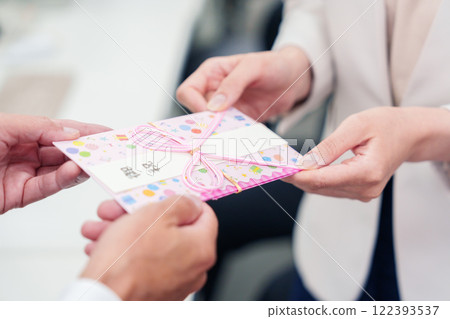 A businesswoman being handed a gift by her boss 122393537