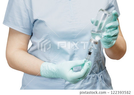 Female physician in latex gloves holding syringe and picking up liquid medicine for injection. 122393582