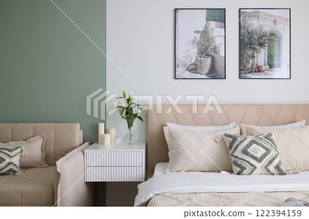 A cozy modern bedroom featuring elegant decor combined with a soothing green accent wall 122394159