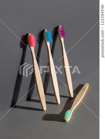 Colorful bamboo toothbrushes on a grey two tones background with hard shadow closeup, mockup Colorful bamboo toothbrushes on a grey two tones background with hard shadow closeup, mockup 122394546