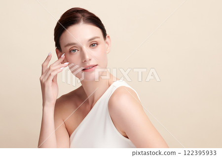Beautiful young woman with clean fresh skin on beige background, Face care, Facial treatment, Cosmetology, beauty and spa, women portrait. Beautiful young woman with clean fresh skin on beige background, Face care, Facial treatment, Cosmetology, beauty and spa, women portrait. 122395933