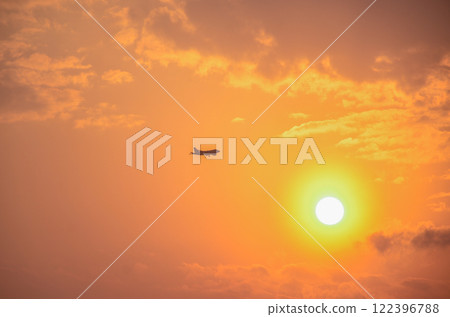 飛機飛行與夕陽重疊 飛機飛行與夕陽重疊 122396788