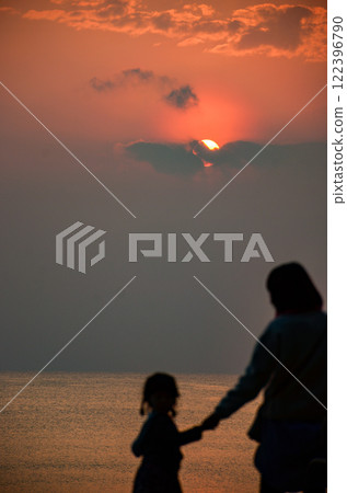 Parents and children playing on the beach in the evening, silhouette Parents and children playing on the beach in the evening, silhouette 122396790