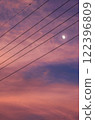 The moon seen through the power lines, sunset 122396809