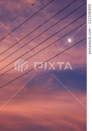 The moon seen through the power lines, sunset 122396809