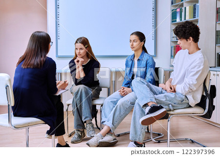 Group mental therapy, teenagers students talking with female psychologist, school counselor Group mental therapy, teenagers students talking with female psychologist, school counselor 122397396