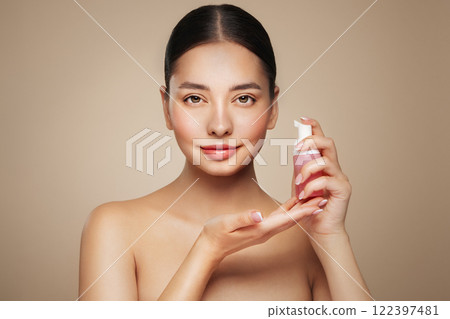 Young woman shows off a bottle with a foam dispenser for washing Young woman shows off a bottle with a foam dispenser for washing 122397481